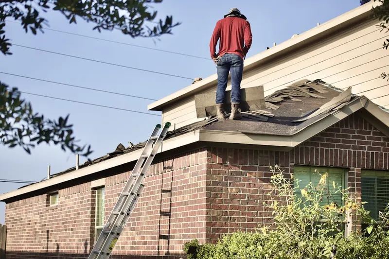 Professional roofer working on a residential roof in Deephaven